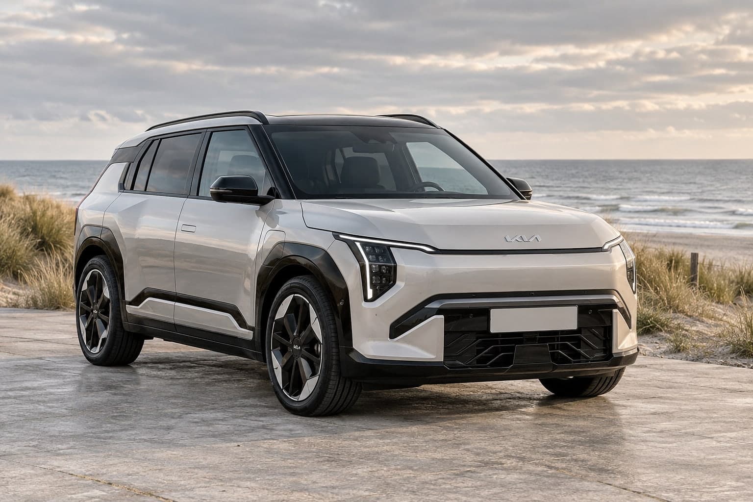 Sand-coloured Kia EV3 by the dunes and sea